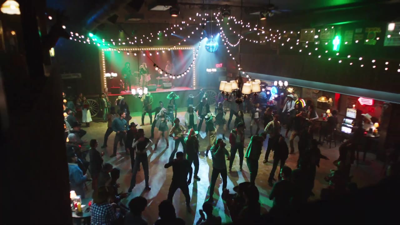 Line dancers on a dance floor in Expedia’s Two Step film